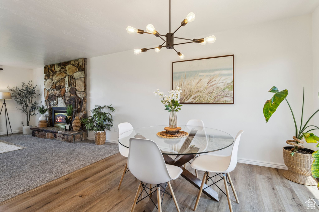Dining room with wood finished floors, a chandelier, and baseboards