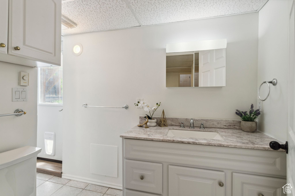 Bathroom featuring vanity, toilet, and tile patterned floors