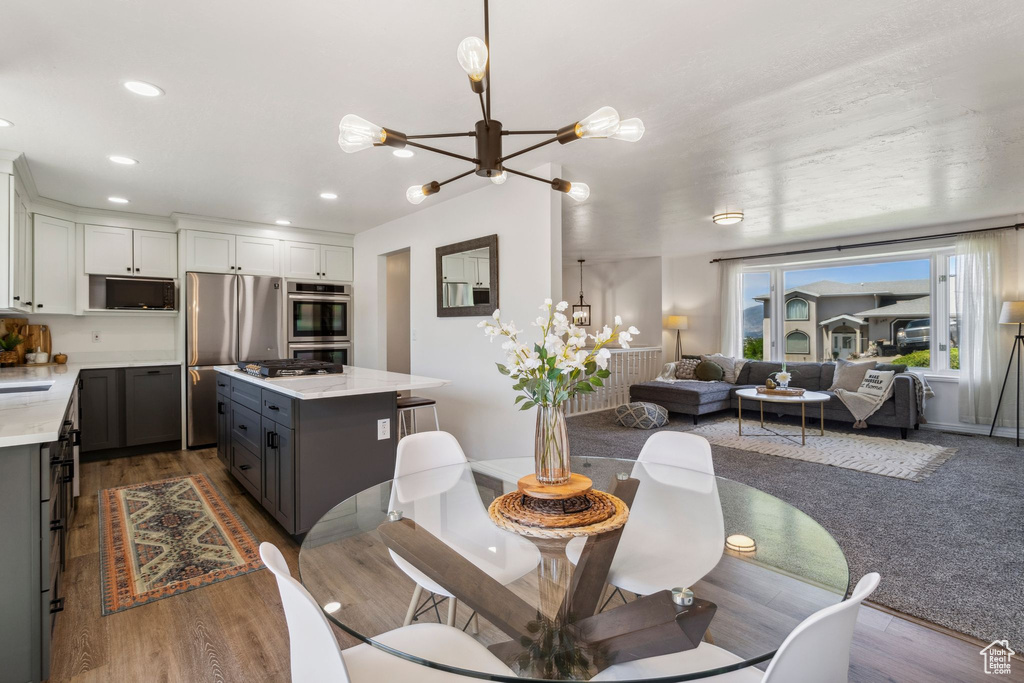Dining space featuring a chandelier, recessed lighting, wood finished floors, and baseboards