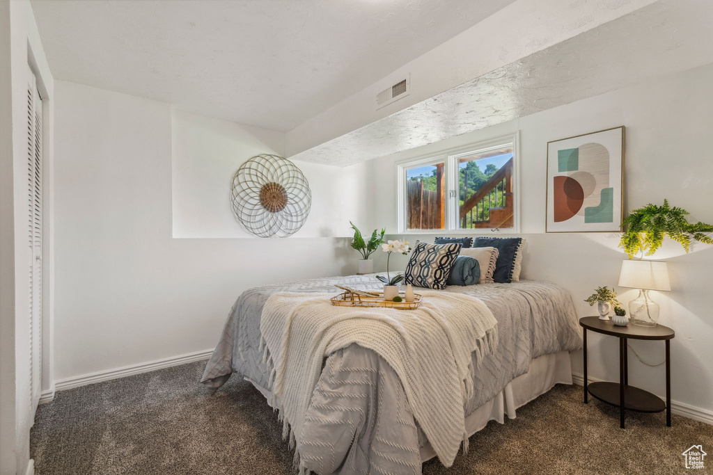 Bedroom featuring carpet and baseboards