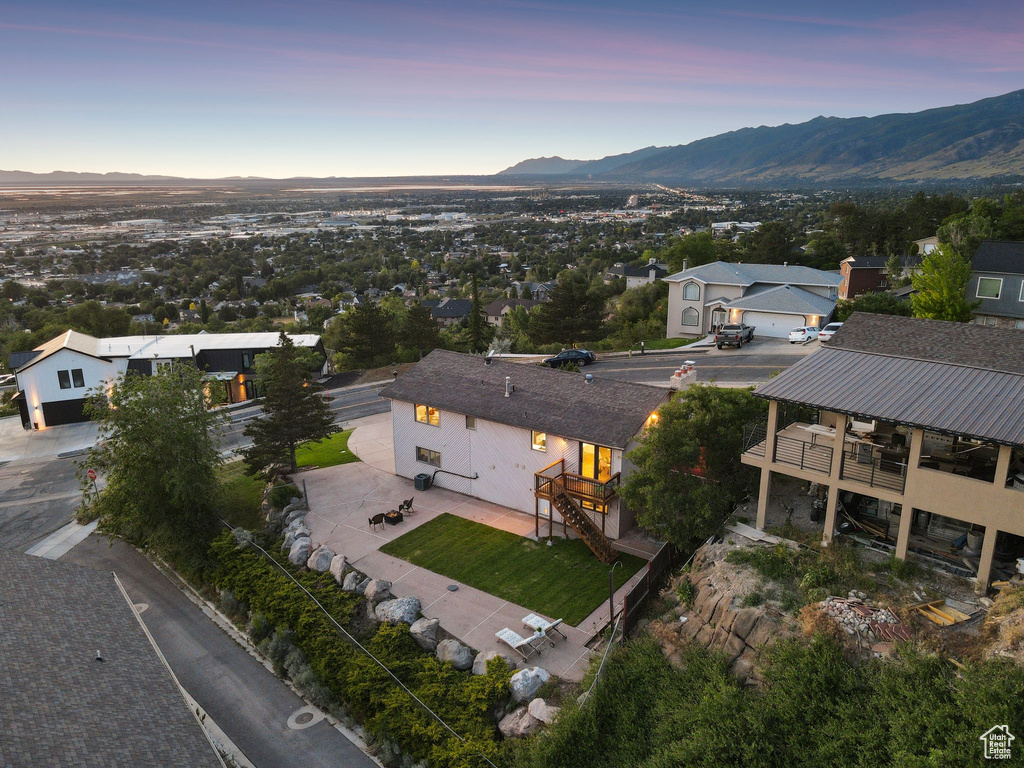 Aerial view of property and surrounding area featuring a mountain backdrop