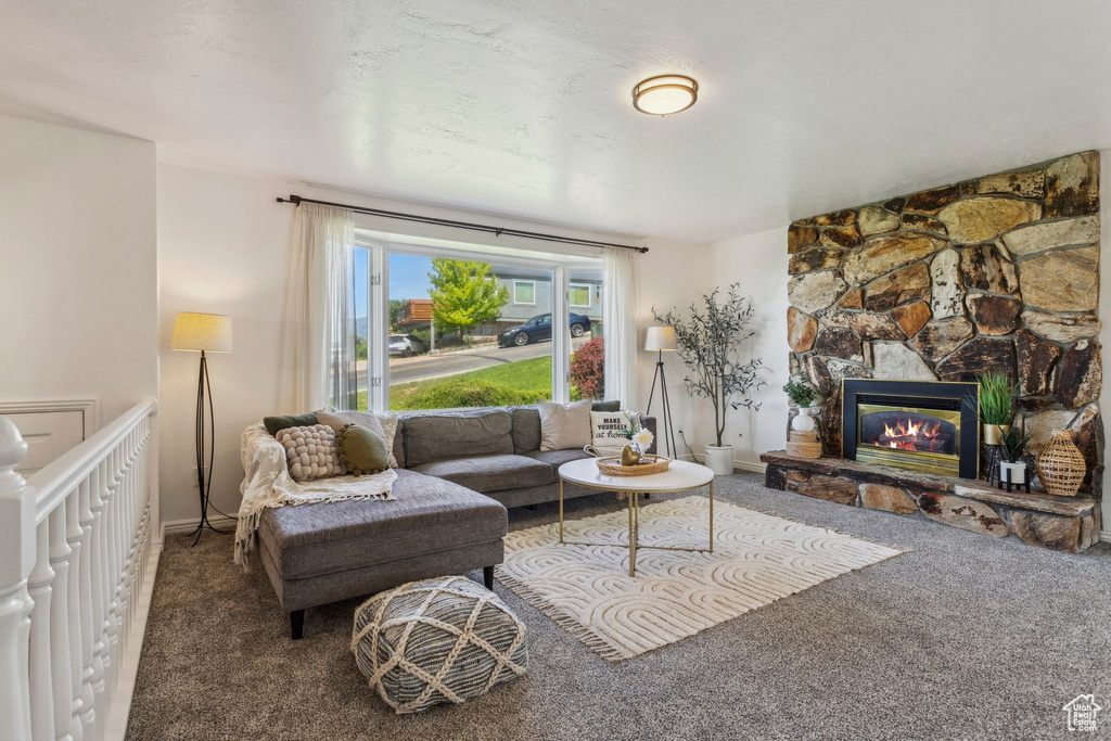 Living room featuring carpet, a fireplace, and baseboards