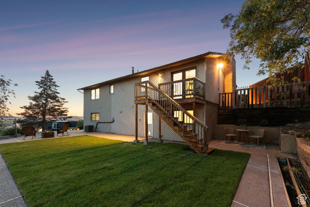Rear view of house with stairway, a patio area, a wooden deck, and a fire pit