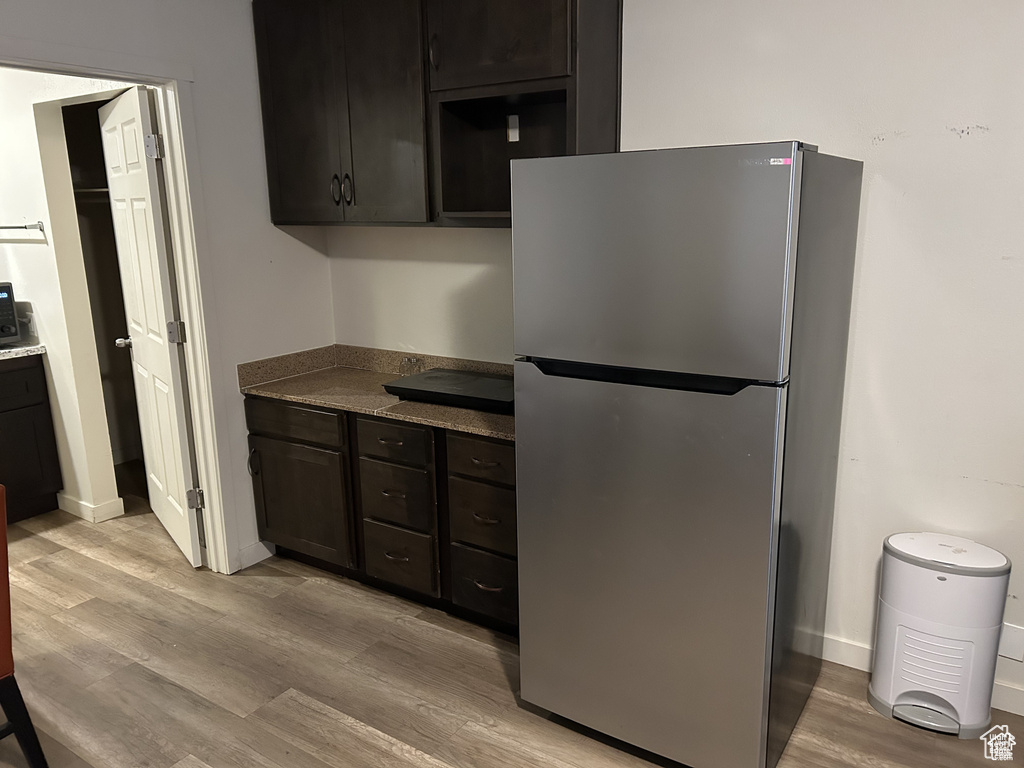 Kitchen with freestanding refrigerator, light wood-style floors, and baseboards