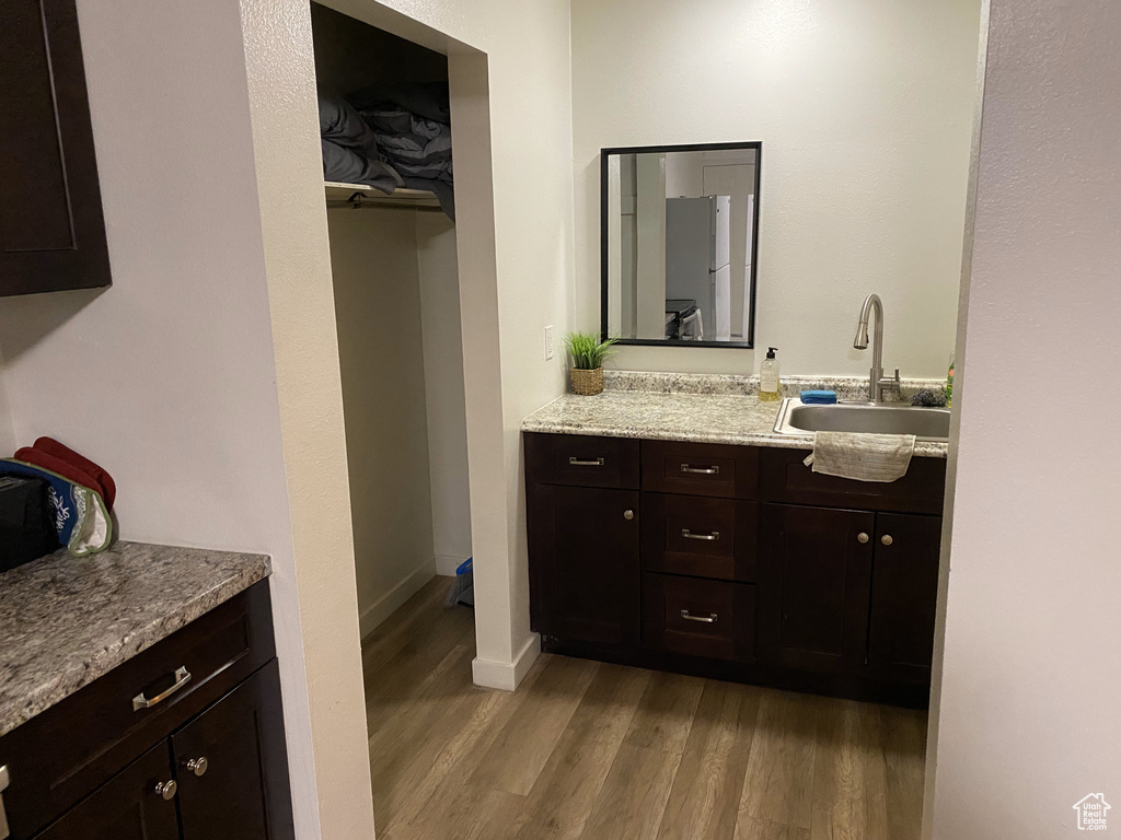 Bathroom with wood finished floors, vanity, and baseboards