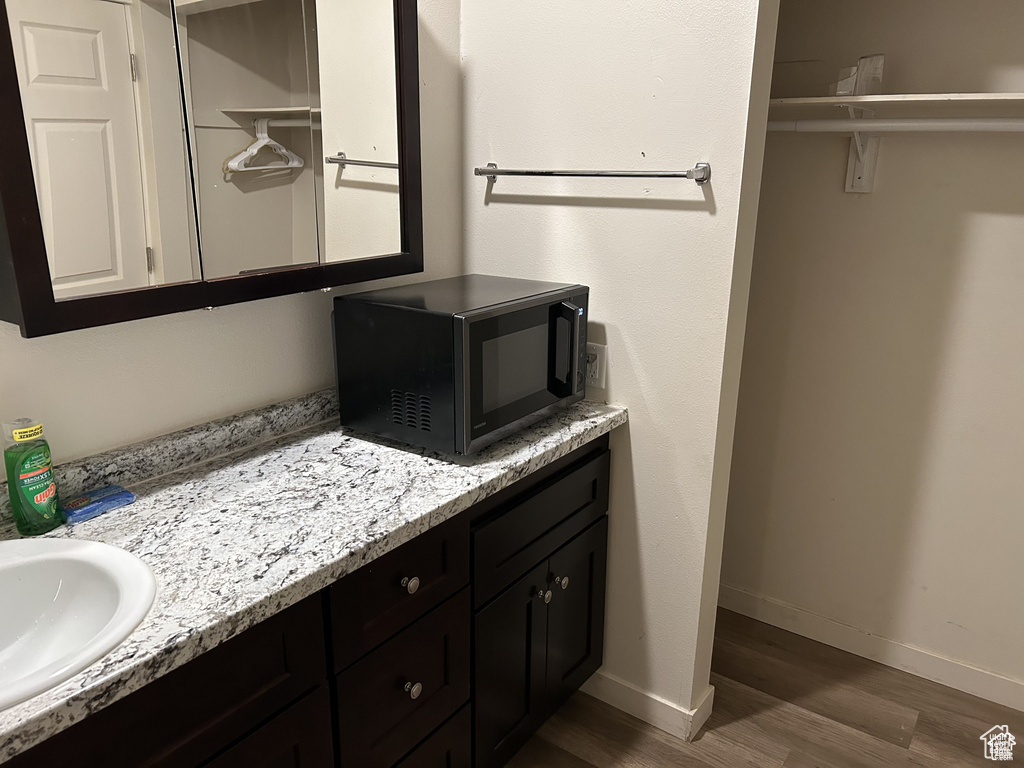 Bathroom with wood finished floors, vanity, and baseboards
