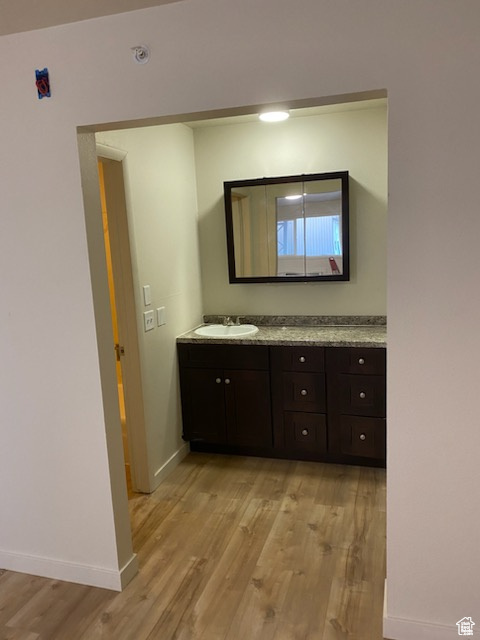 Bathroom featuring wood finished floors, baseboards, and vanity