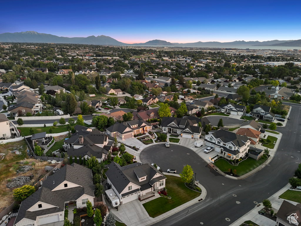 Aerial view of property and surrounding area featuring mountains and nearby suburban area