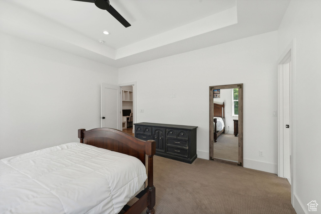 Bedroom with light colored carpet, a tray ceiling, baseboards, a ceiling fan, and recessed lighting