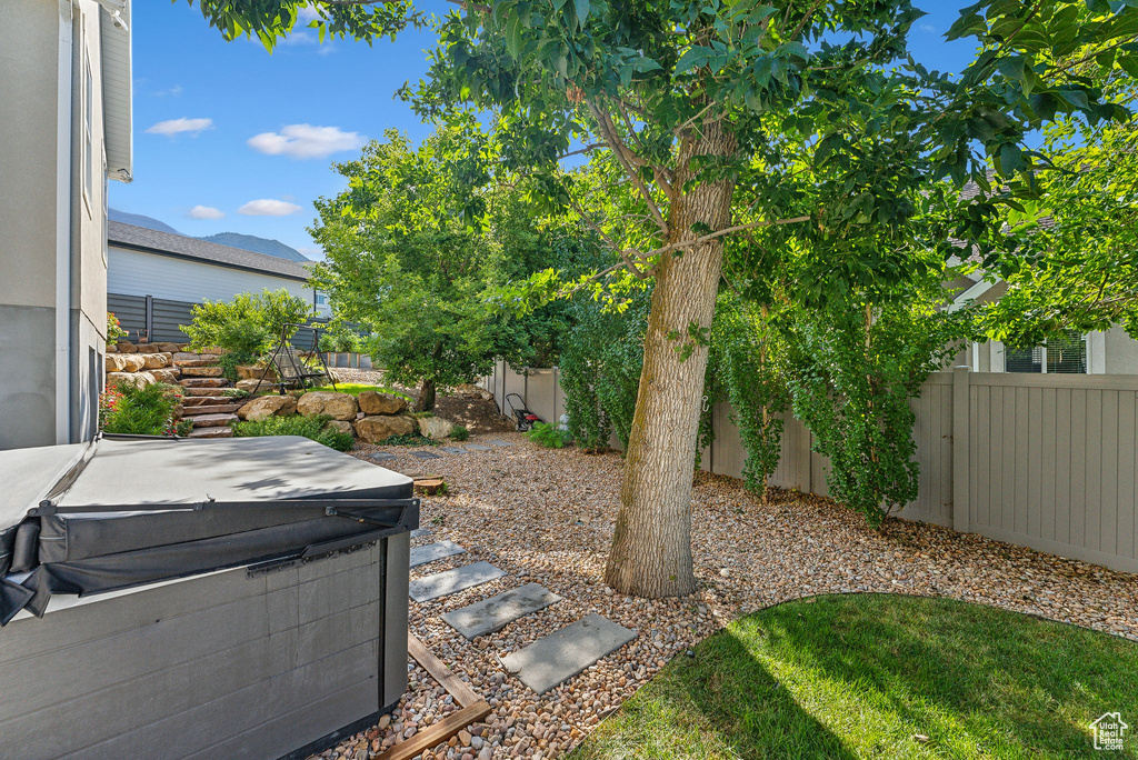 Fenced backyard with a hot tub