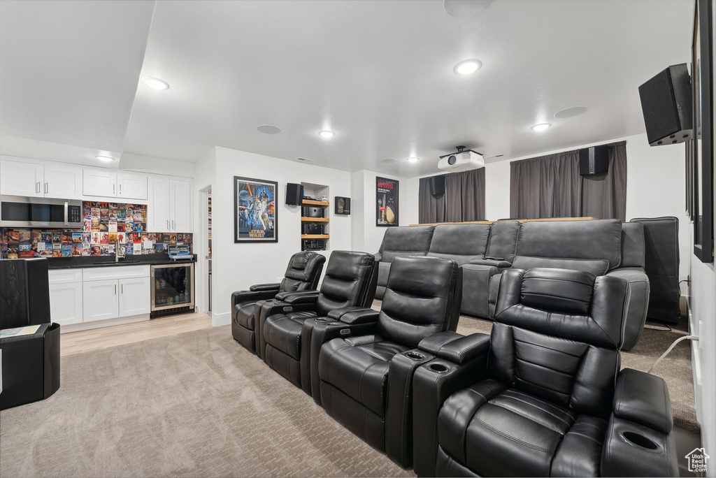 Home theater with bar with sink, recessed lighting, wine cooler, and light carpet