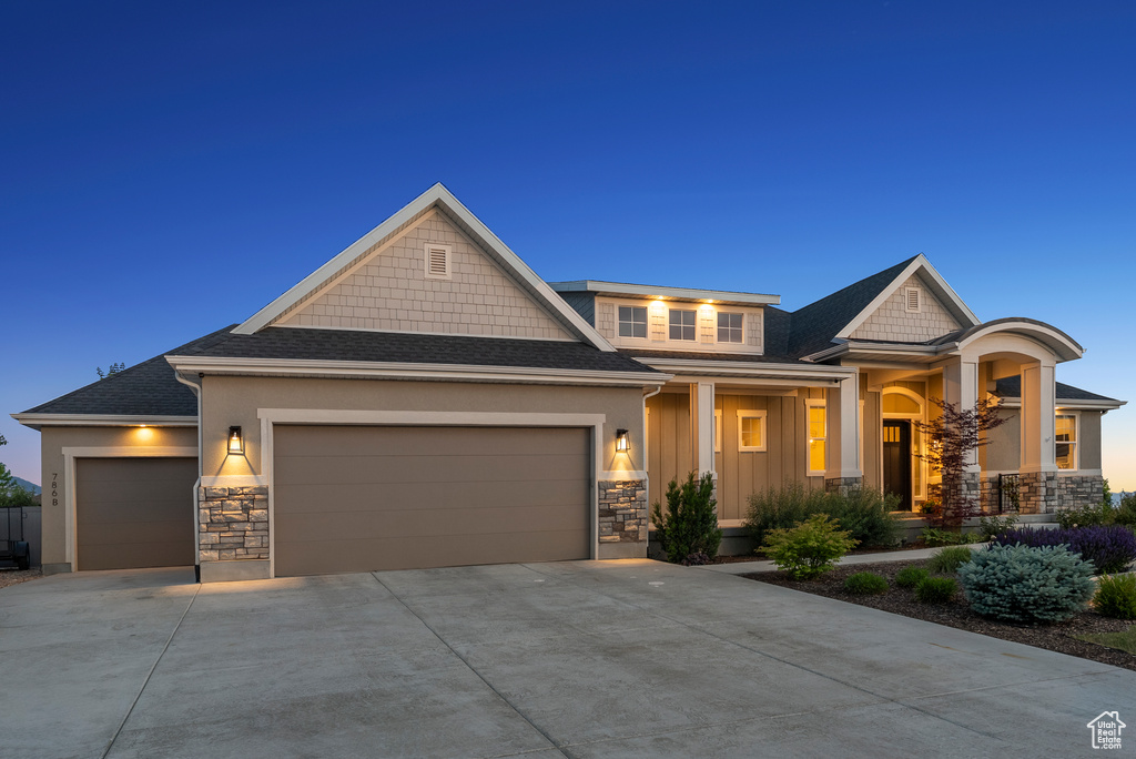 Craftsman-style home with an attached garage, stone siding, concrete driveway, roof with shingles, and covered porch