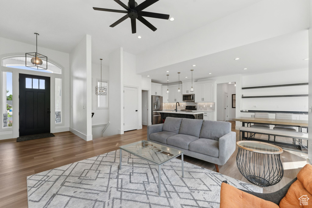 Living area with wood finished floors, ceiling fan, and recessed lighting