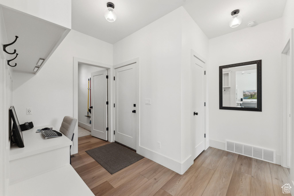 Unfurnished office with light wood-style flooring and baseboards