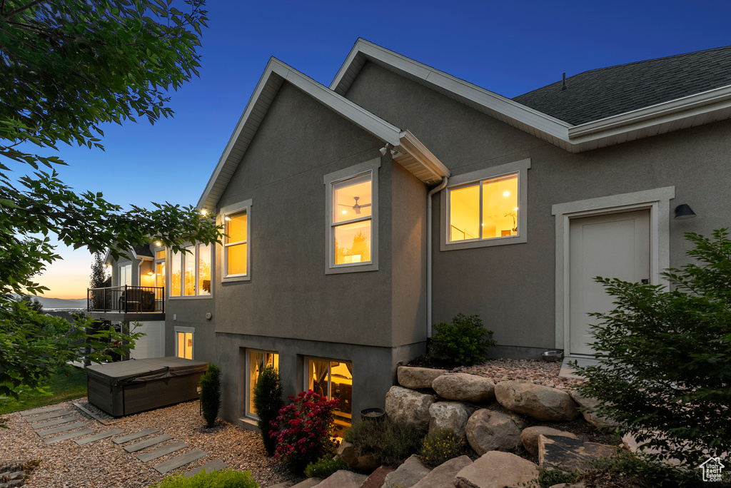 View of home\\\'s exterior featuring stucco siding, a hot tub, and a balcony