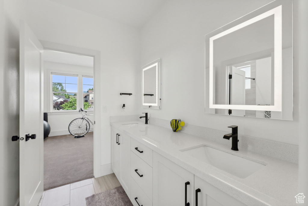 Full bath featuring double vanity and baseboards
