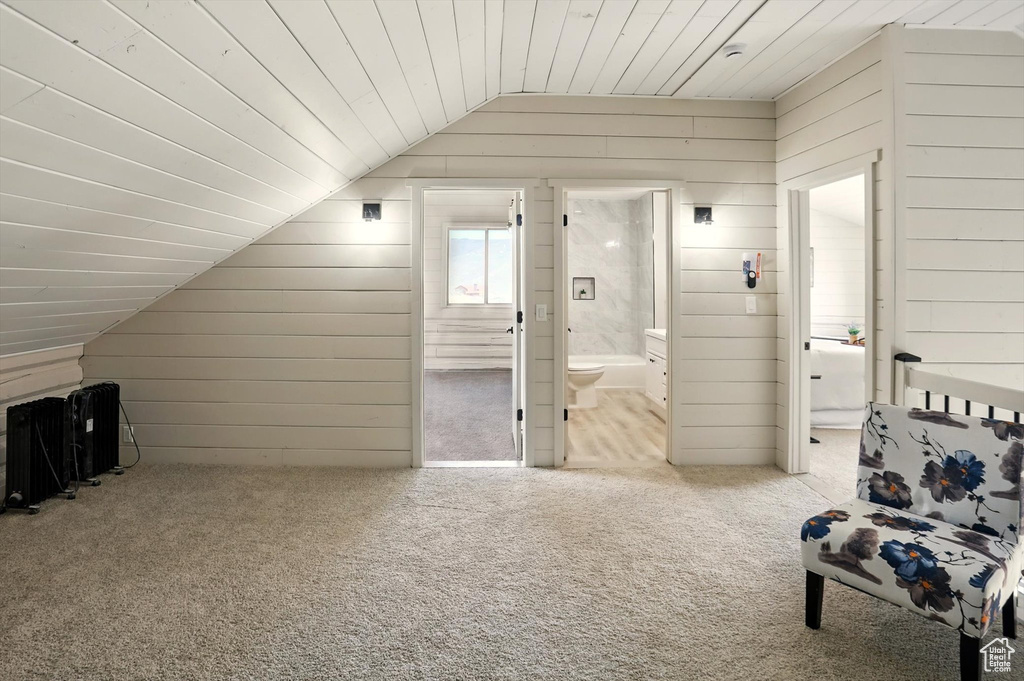 Additional living space featuring lofted ceiling, carpet, wooden walls, and wood ceiling