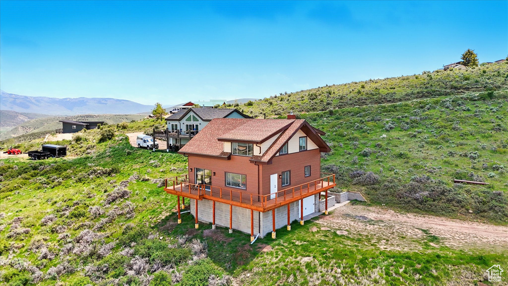 Aerial view of property and surrounding area featuring a mountain backdrop
