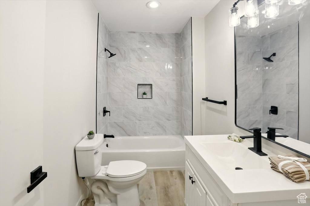 Full bathroom with toilet, vanity, and shower / bath combination