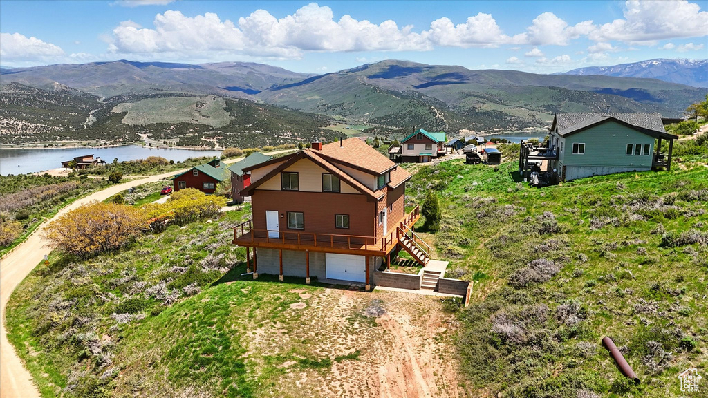Aerial view of property and surrounding area featuring a water and mountain view