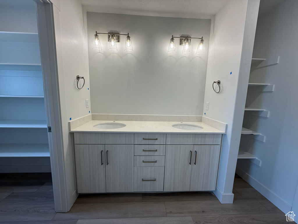 Bathroom with double vanity and wood finished floors