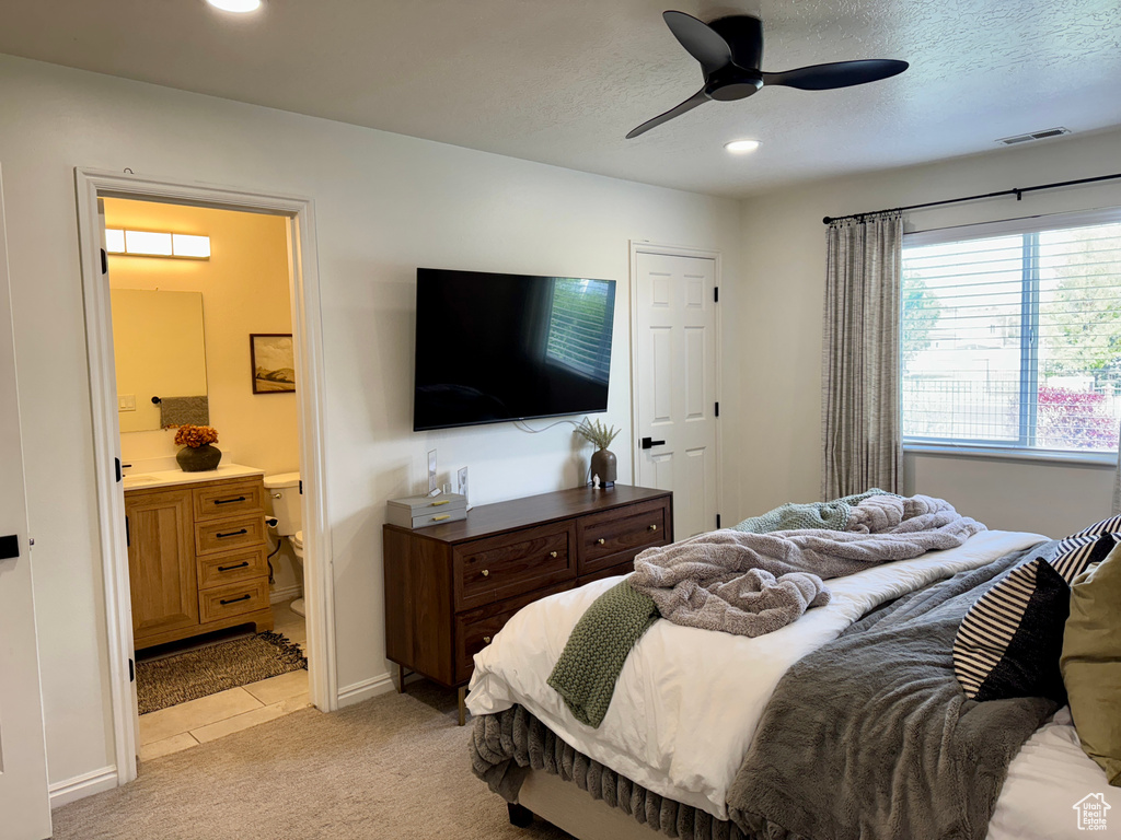 Bedroom with light colored carpet, recessed lighting, connected bathroom, baseboards, and ceiling fan