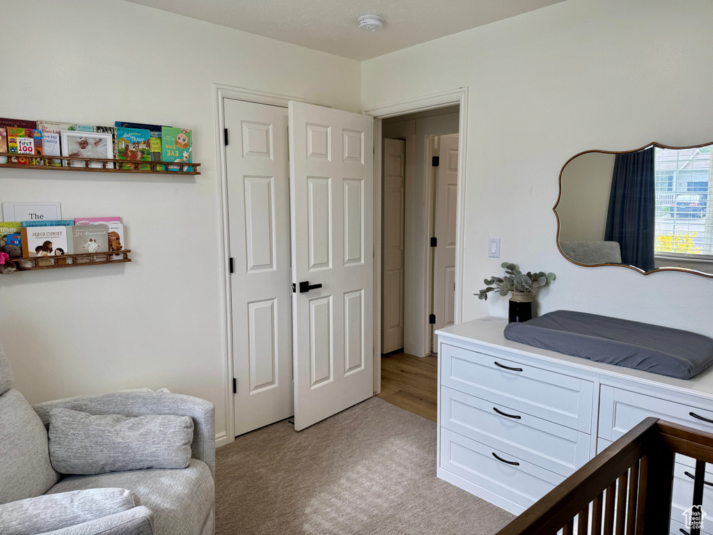 Bedroom with light colored carpet and a closet