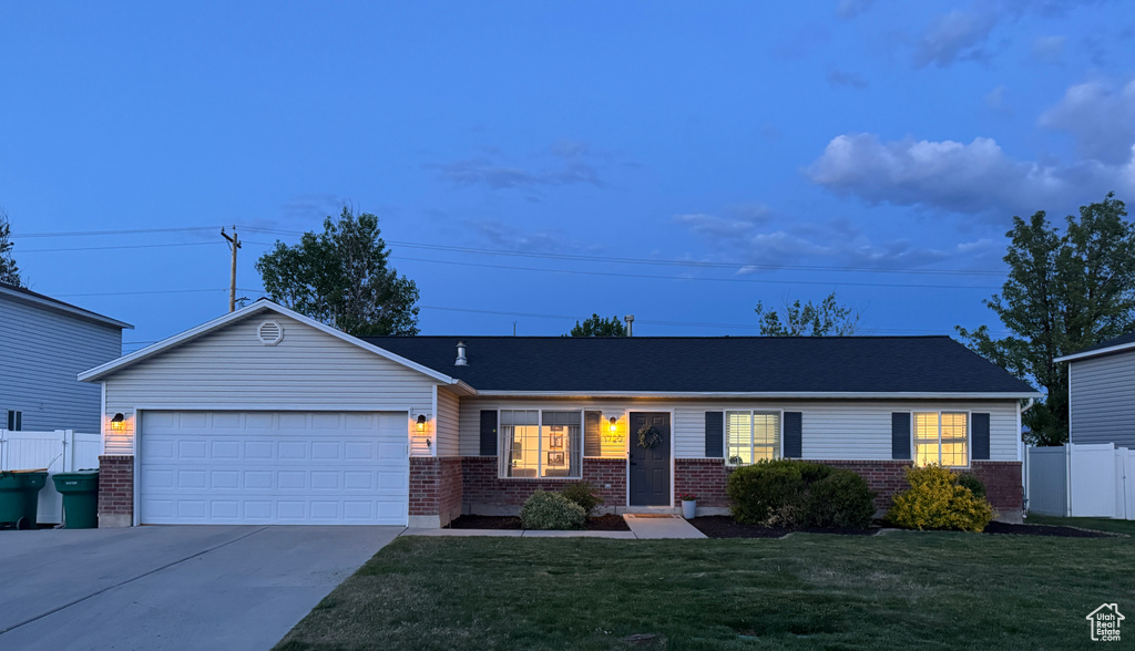 Single story home featuring brick siding, concrete driveway, and an attached garage