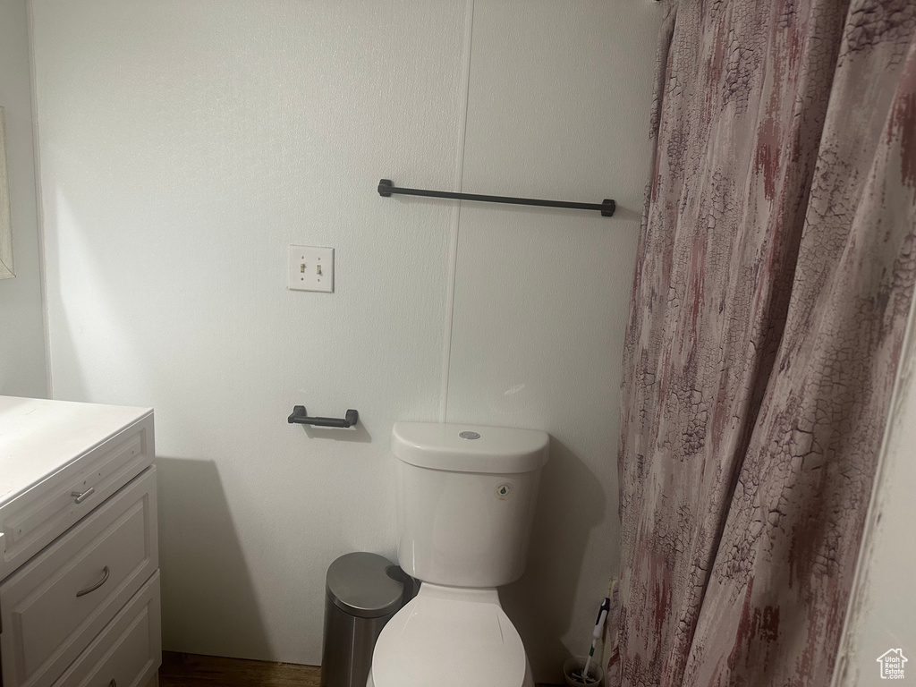 Full bath with vanity, toilet, and curtained shower