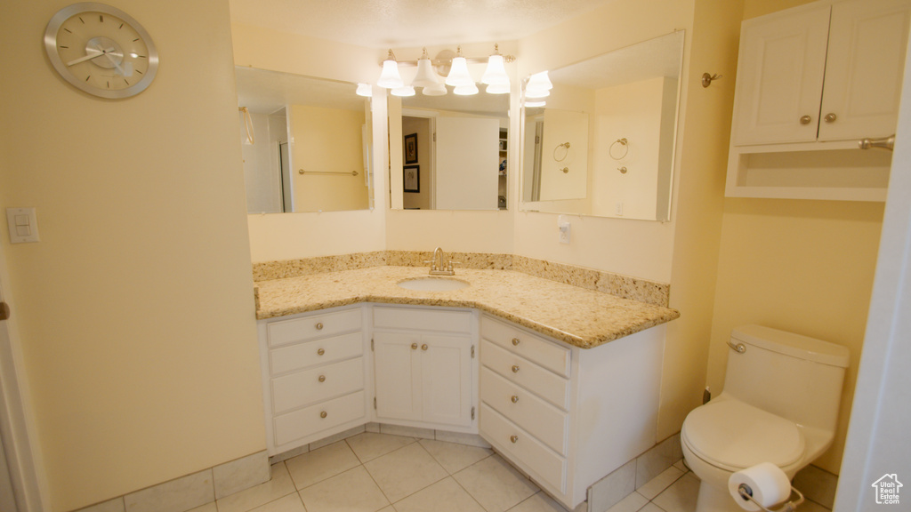 Bathroom featuring toilet, vanity, and tile patterned flooring