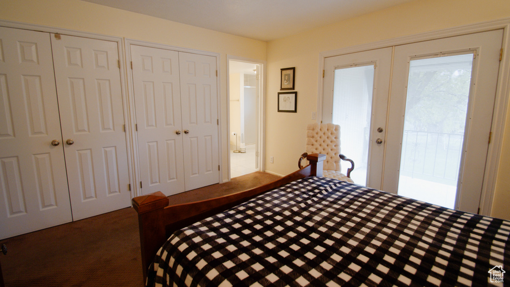 Bedroom featuring french doors, carpet, and two closets
