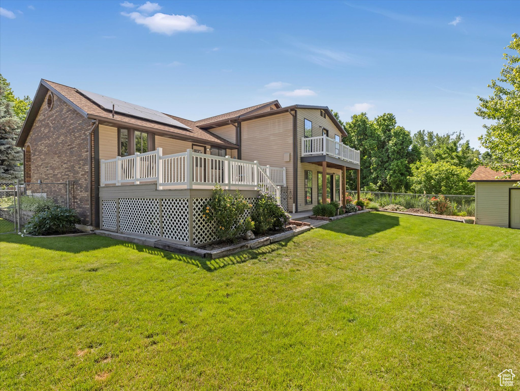 Rear view of house featuring a deck and brick siding