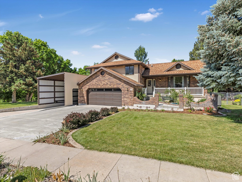 Tri-level home featuring brick siding, concrete driveway, covered porch, and an attached garage