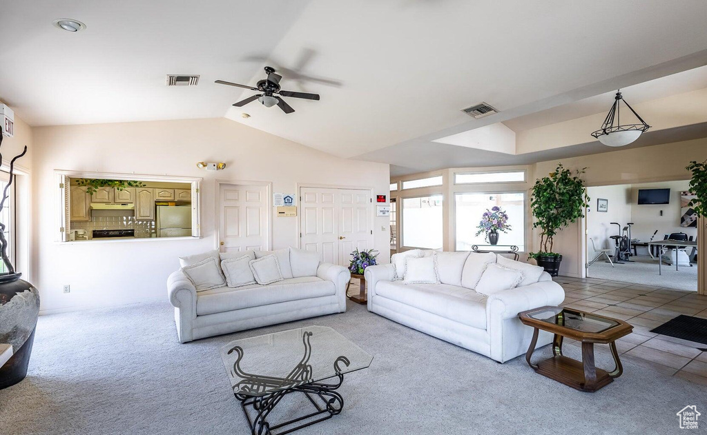 Living area with ceiling fan, light carpet, and lofted ceiling