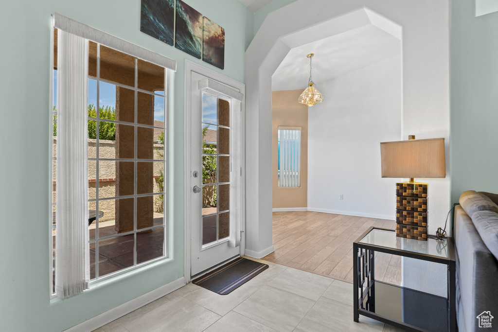 Entryway with healthy amount of natural light, baseboards, and a chandelier