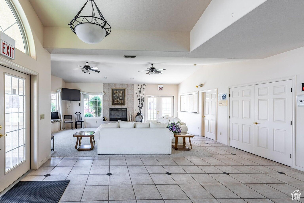 Living area featuring a tile fireplace, ceiling fan, and light tile patterned floors