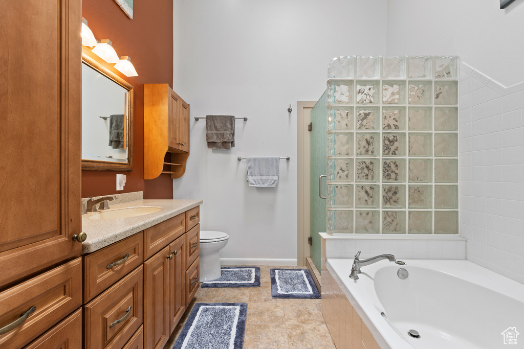 Full bath with vanity, a stall shower, a bath, and toilet