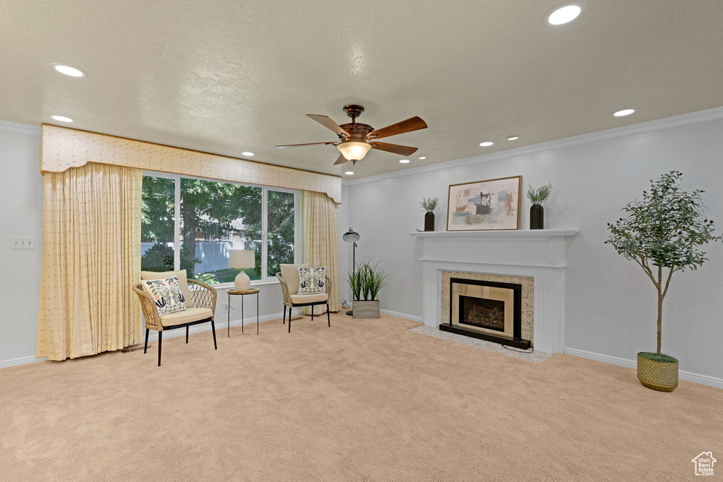 Sitting room with recessed lighting, carpet, a ceiling fan, ornamental molding, and a fireplace