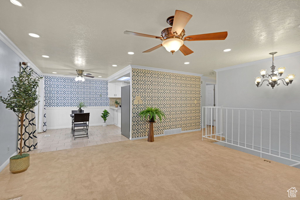 Empty room with wallpapered walls, ceiling fan, recessed lighting, a chandelier, and an accent wall