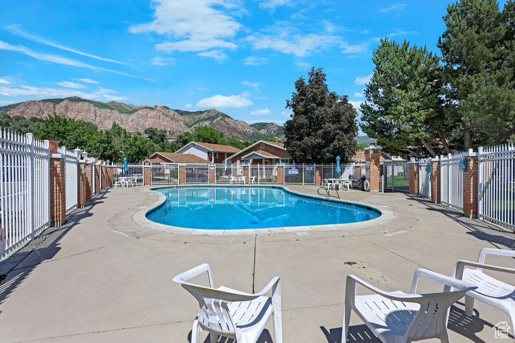 Community pool featuring a mountain view and a patio area