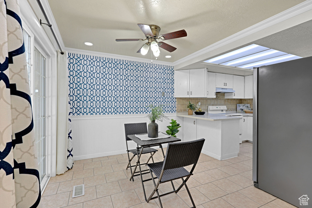 Dining space featuring ornamental molding, ceiling fan, and light tile patterned floors