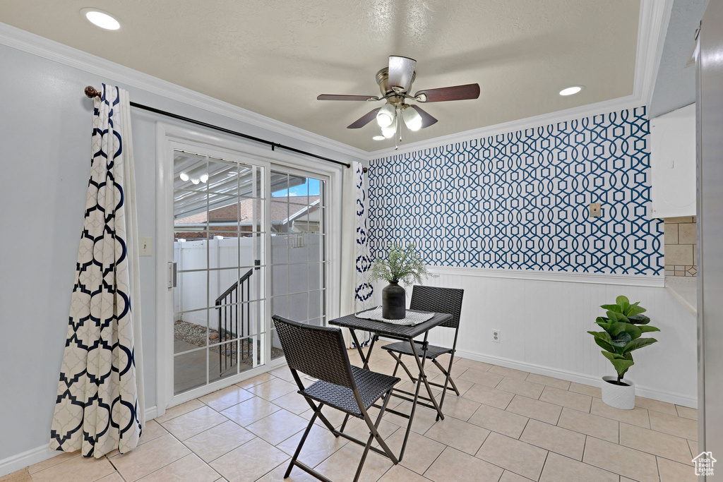 Dining room featuring a ceiling fan, crown molding, baseboards, and light tile patterned flooring