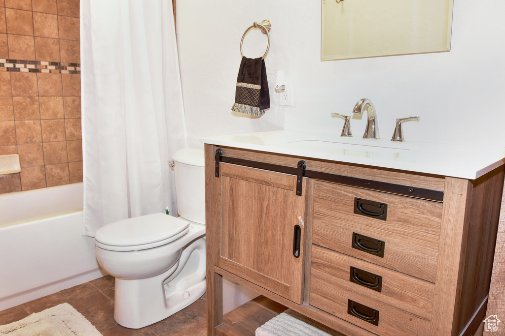 Full bathroom with toilet, vanity, shower / bath combo with shower curtain, and tile patterned flooring