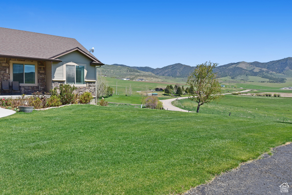 View of grassy yard with a mountain view and a view of countryside