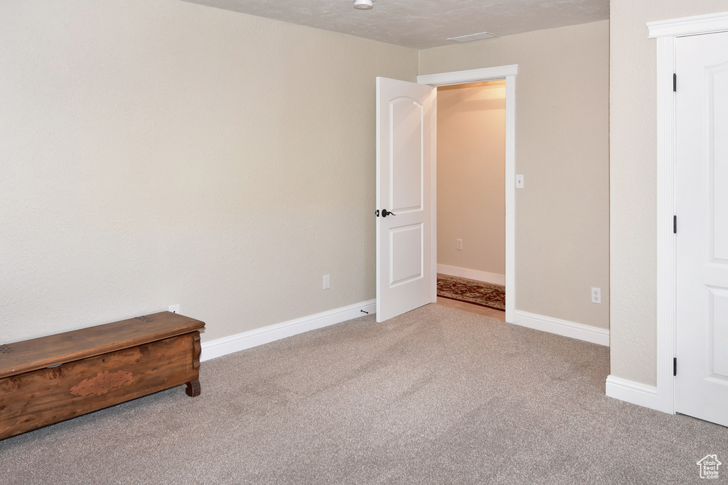 Unfurnished bedroom featuring carpet and baseboards