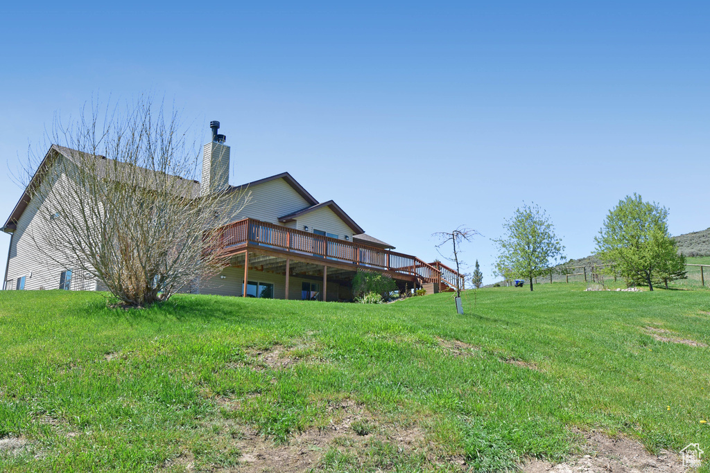 View of grassy yard with a wooden deck