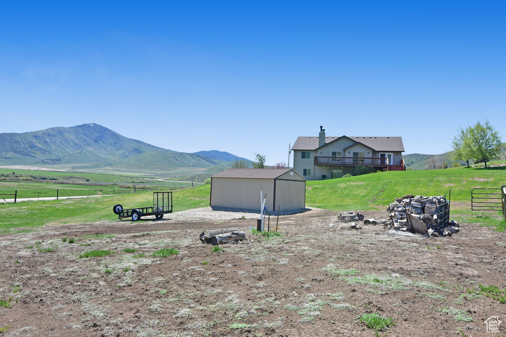 View of yard with a view of rural / pastoral area, an outdoor structure, and a deck with mountain view