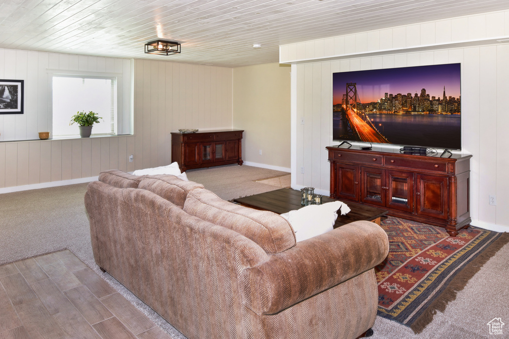 Living area featuring baseboards, wooden ceiling, and wood finished floors