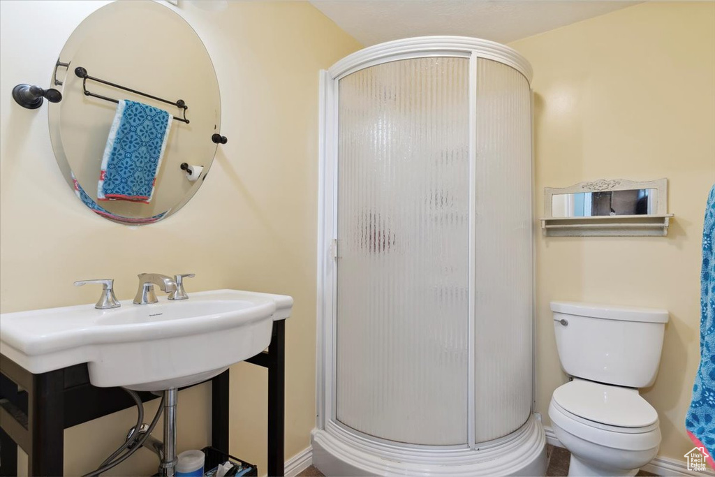 Bathroom with a shower stall, toilet, and baseboards