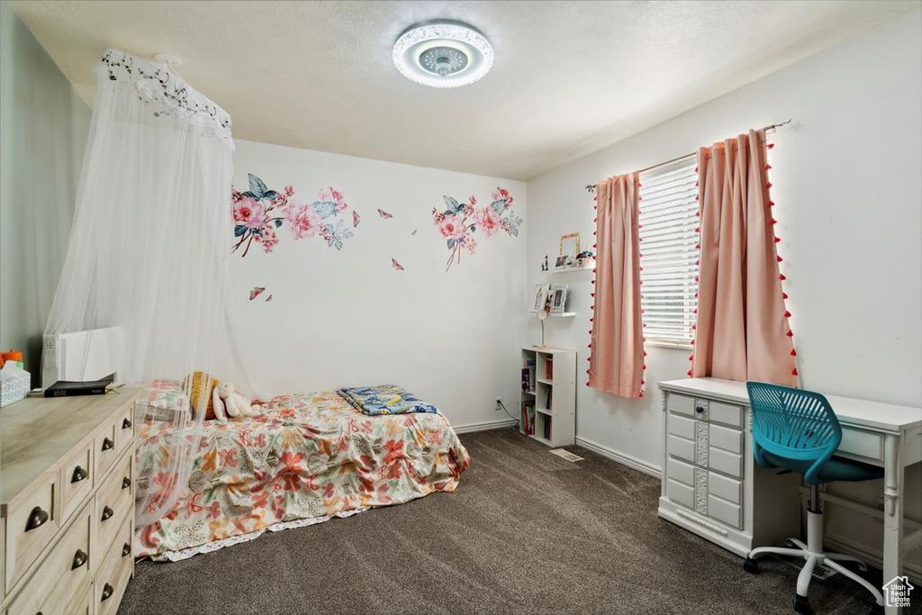 Bedroom featuring dark colored carpet and baseboards